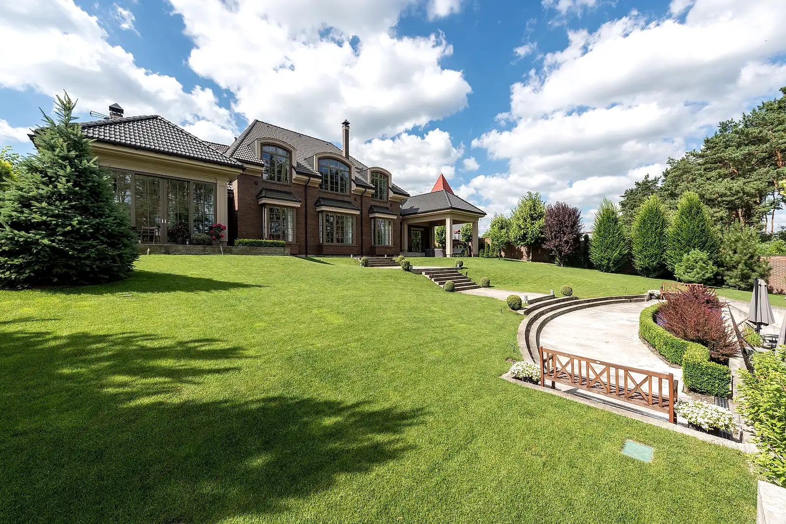 Immaculate estate lawn with terraced stone steps and clipped hedges