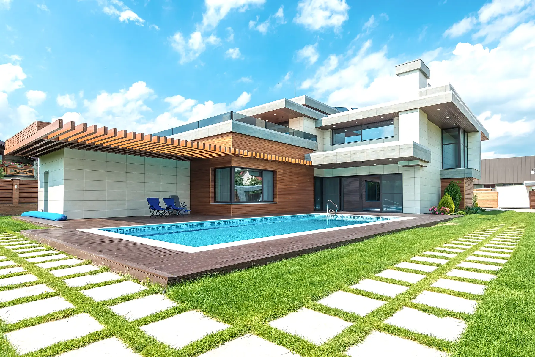 Stepping stone pavers set in a manicured lawn beside a modern pool