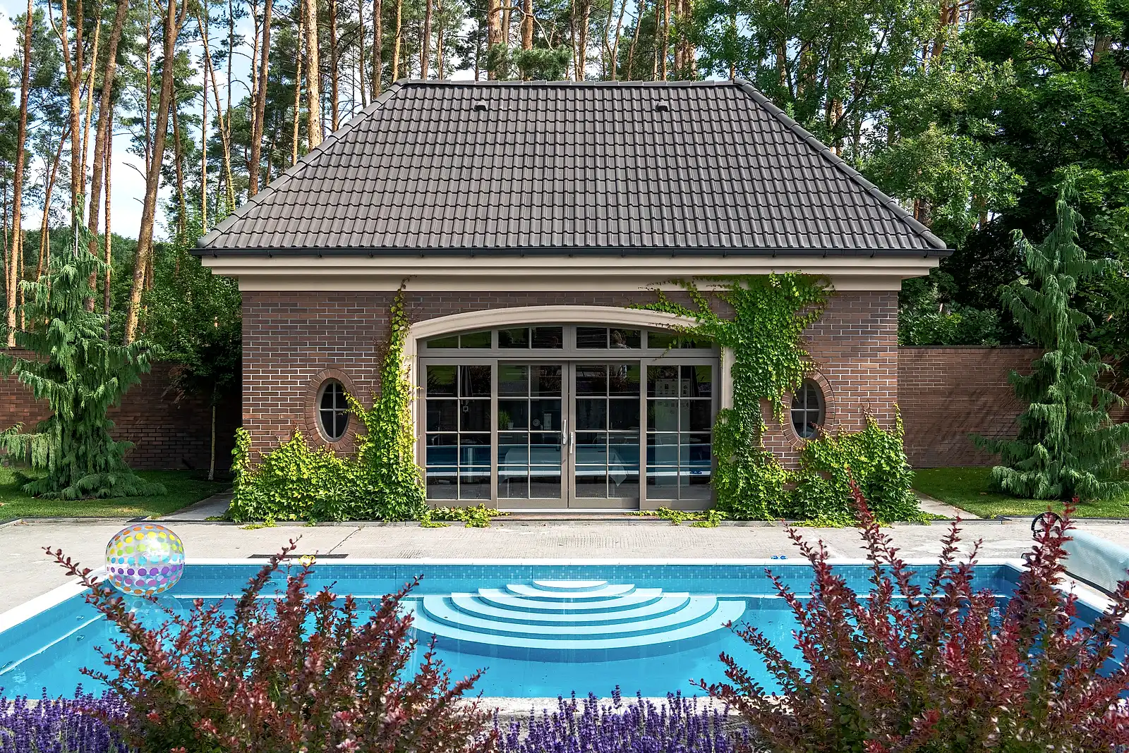 Brick pool house with climbing ivy, lavender and barberry borders