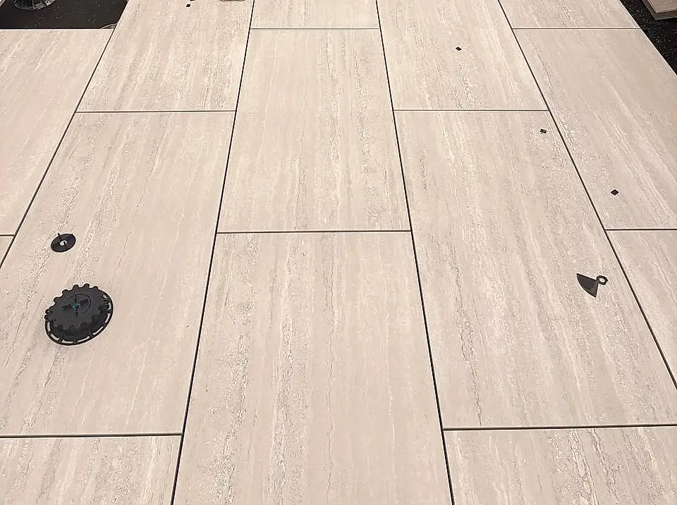 Porcelain pavers on adjustable pedestals during rooftop installation